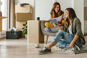 Two women unpacking in apartment