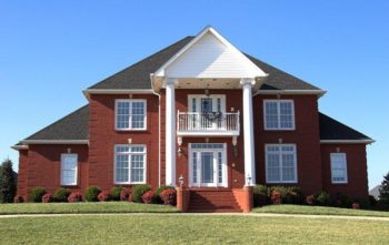 A large brick house in a residential area - Insect IQ pest control in Modesto, CA