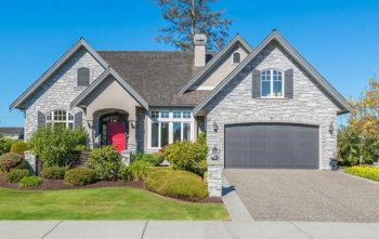 A large white brick house in a residential area - Insect IQ pest control in Modesto, CA